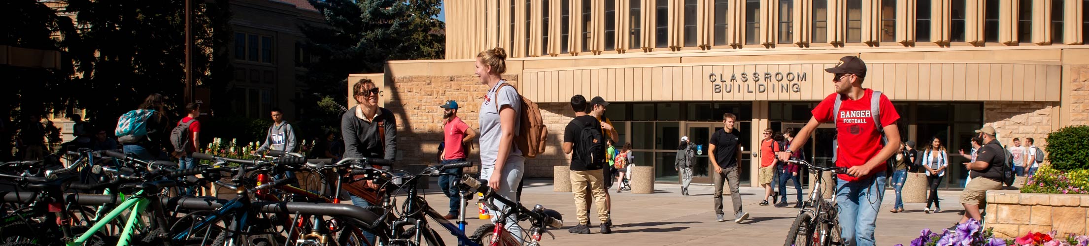Picture of students walking and biking on campus.