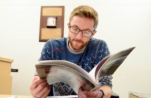 A student reads a book while studying