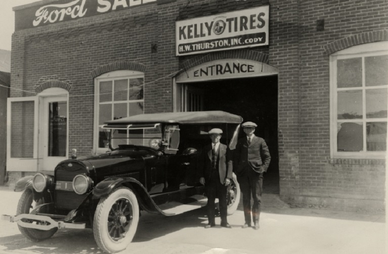 Two people stand outside Kelly Tires business