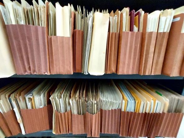 Cases of paper file folders on a shelf