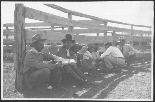 Photograph of Robert Carey (second from the right in the white shirt) and his ranch hand, Walter Newell (first on the right), talking to ranch hands at the Carey Ranch, ca. 1900. 