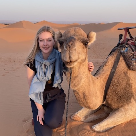 student sitting next to a camel