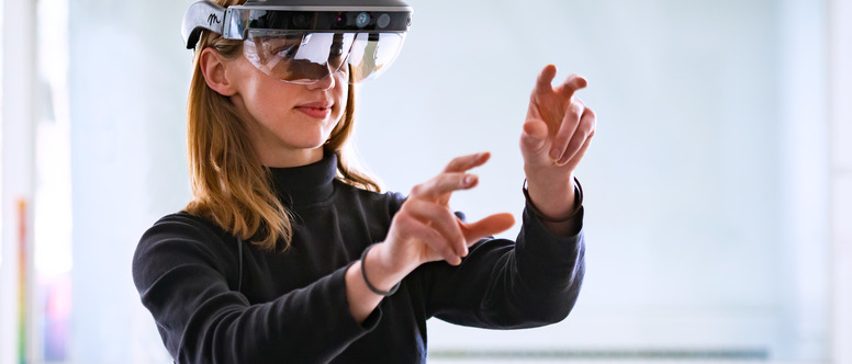 Student wearing a virtual reality headset with her hands up 