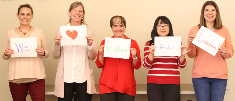ECTL staff holding up signs saying "We Heart Teaching and Learning"