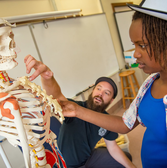 Teacher and student touching a skeleton