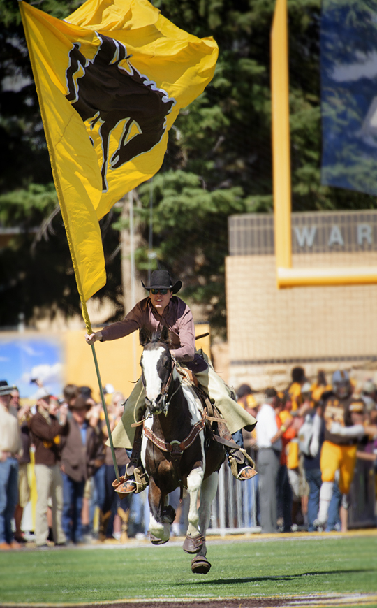 Wyoming charge with flags at game