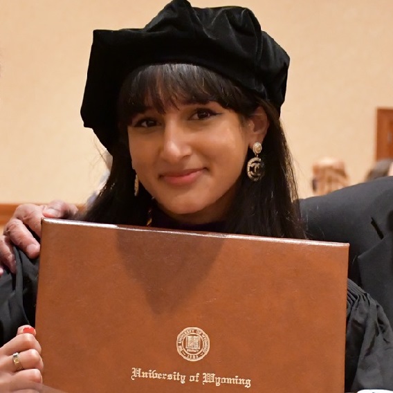 student at graduation holding diploma cover