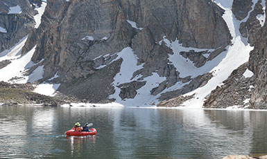 people boating on a mountain lake