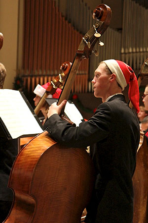 man in a Santa hat playing a string bass