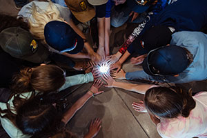 people putting hands in to a circle of light