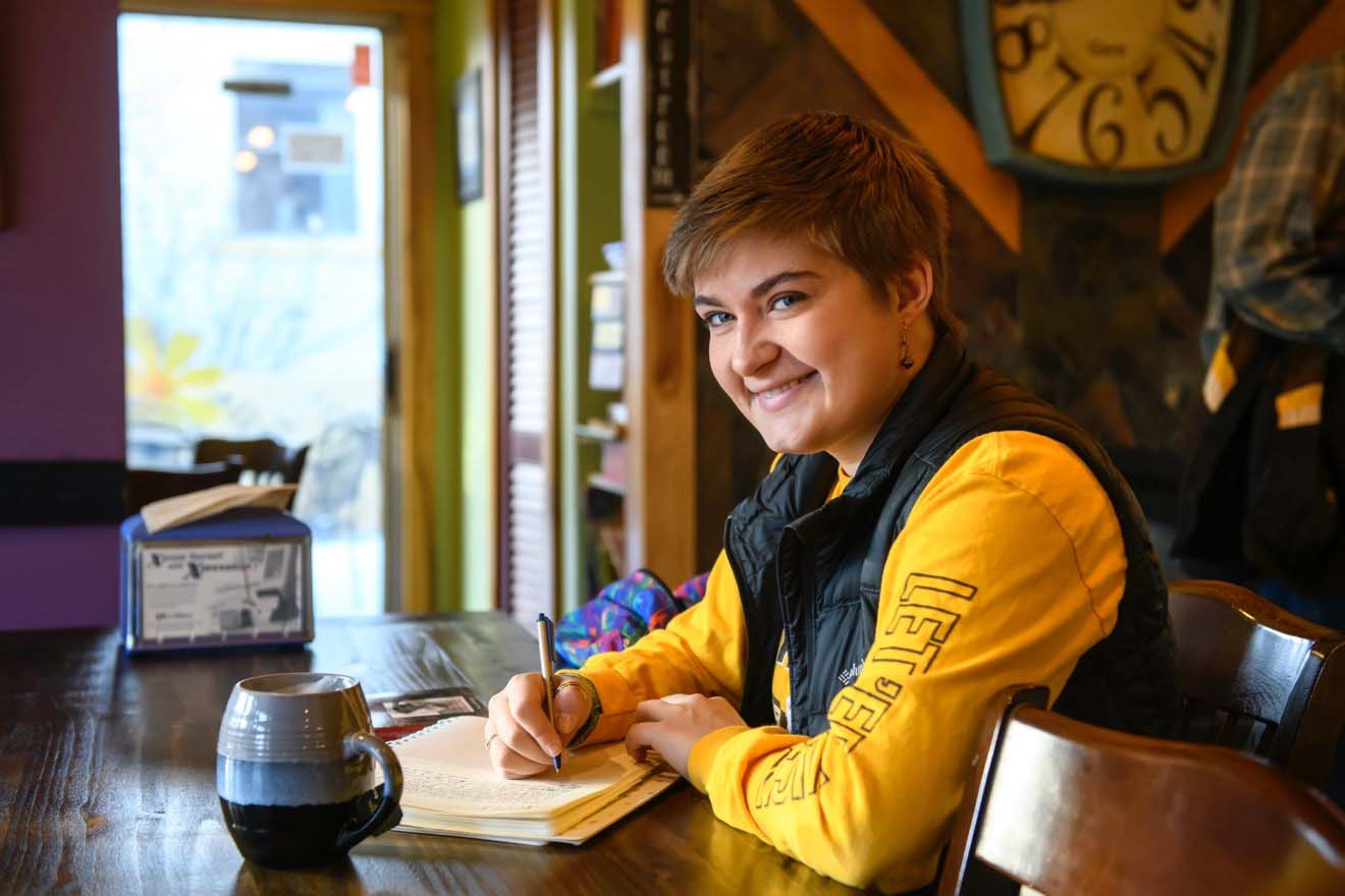 Female student studying in a coffee shop setting.