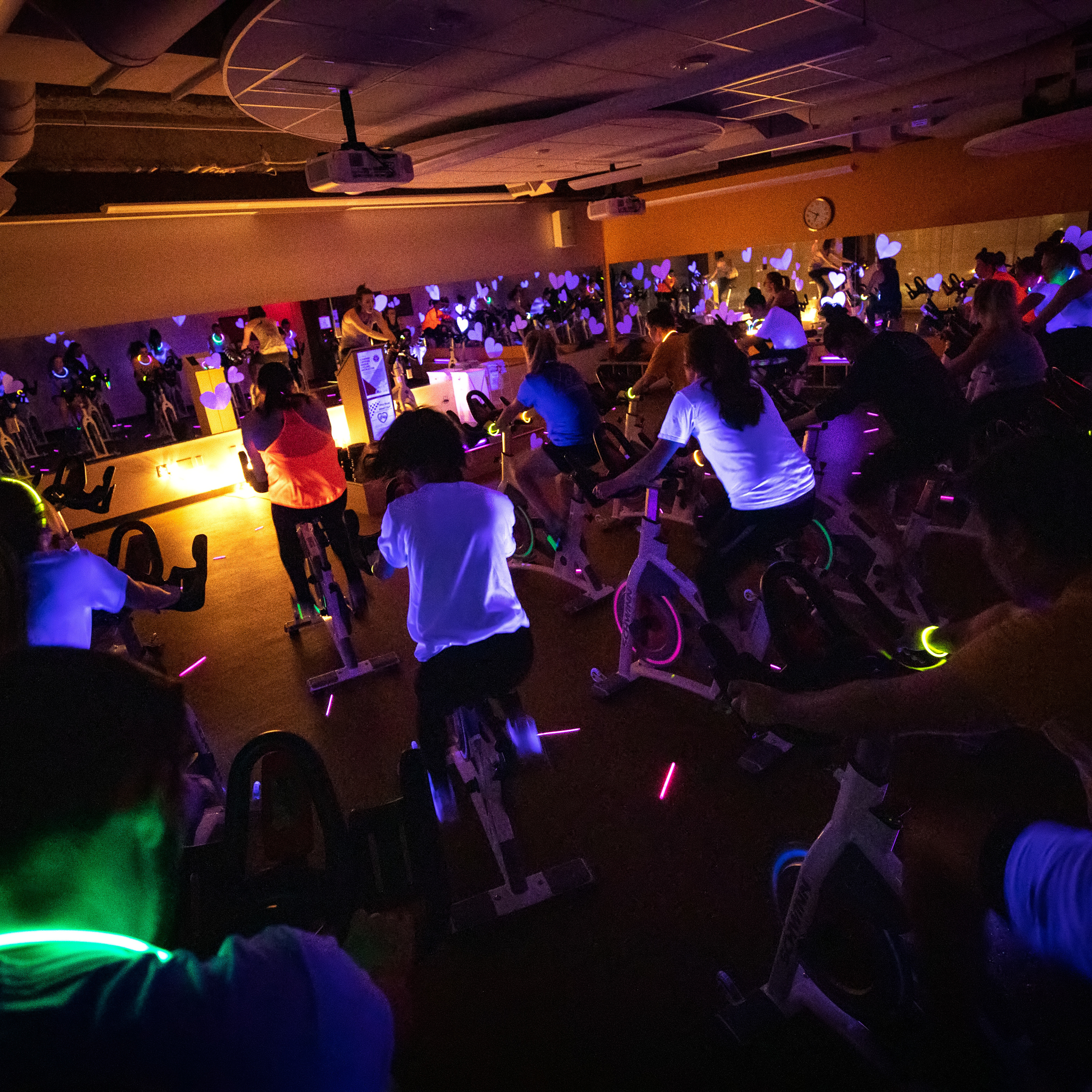 Students participate in a glow spin class