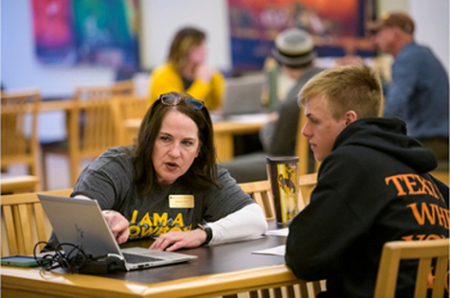 A UW advisor works with a student on their computer.