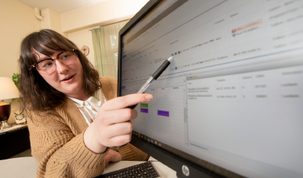 Student pointing at computer screen with a pencil