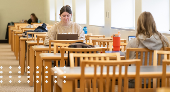 a student sits at a table in the library