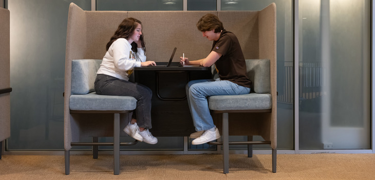 Two students study at a table together