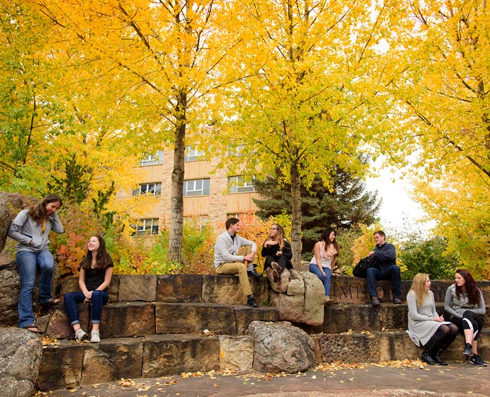 students sitting outside in autumn