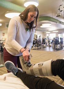 woman putting a medical boot on a person's foot